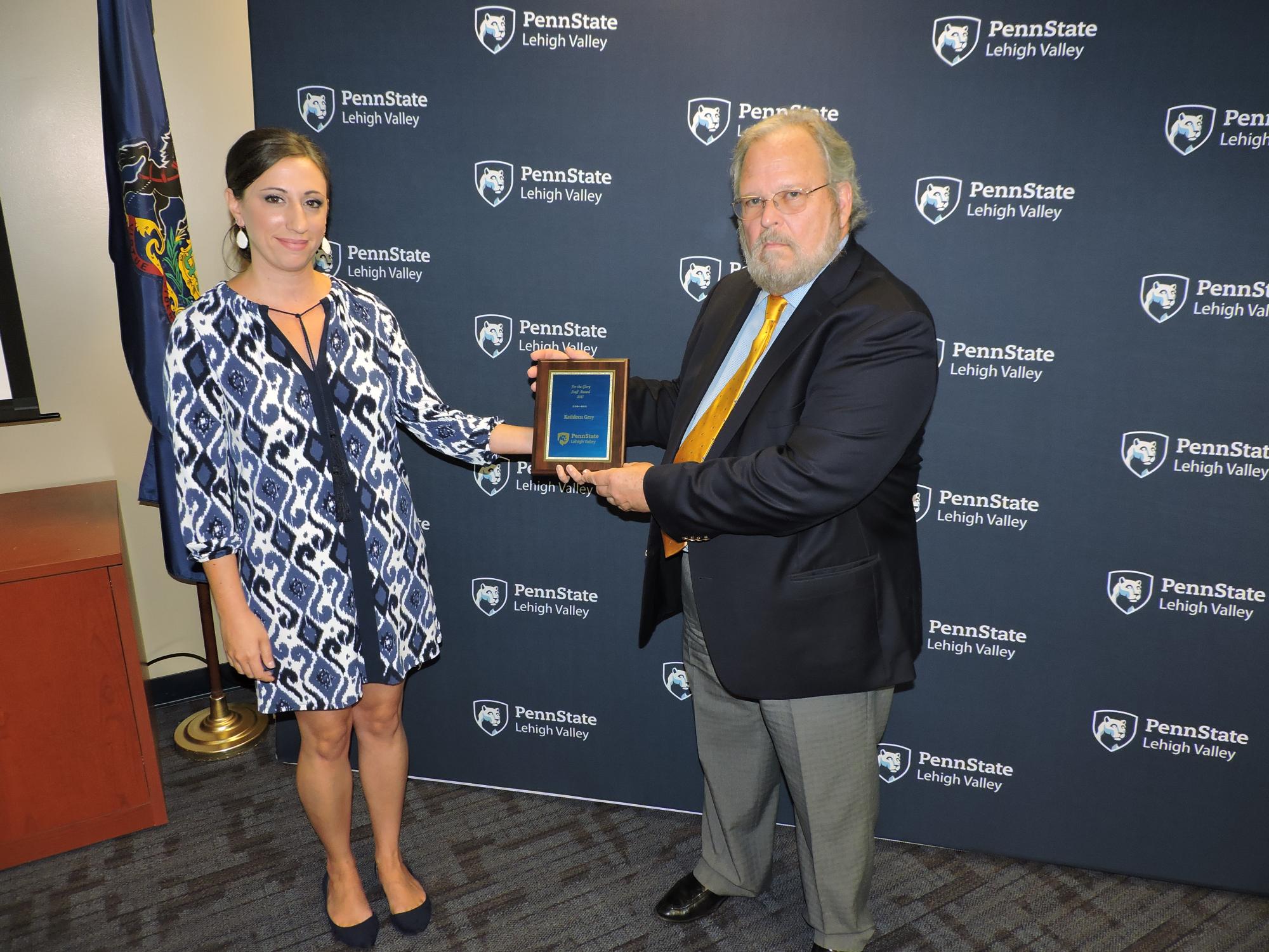 two people leave a space for award winner who has passed