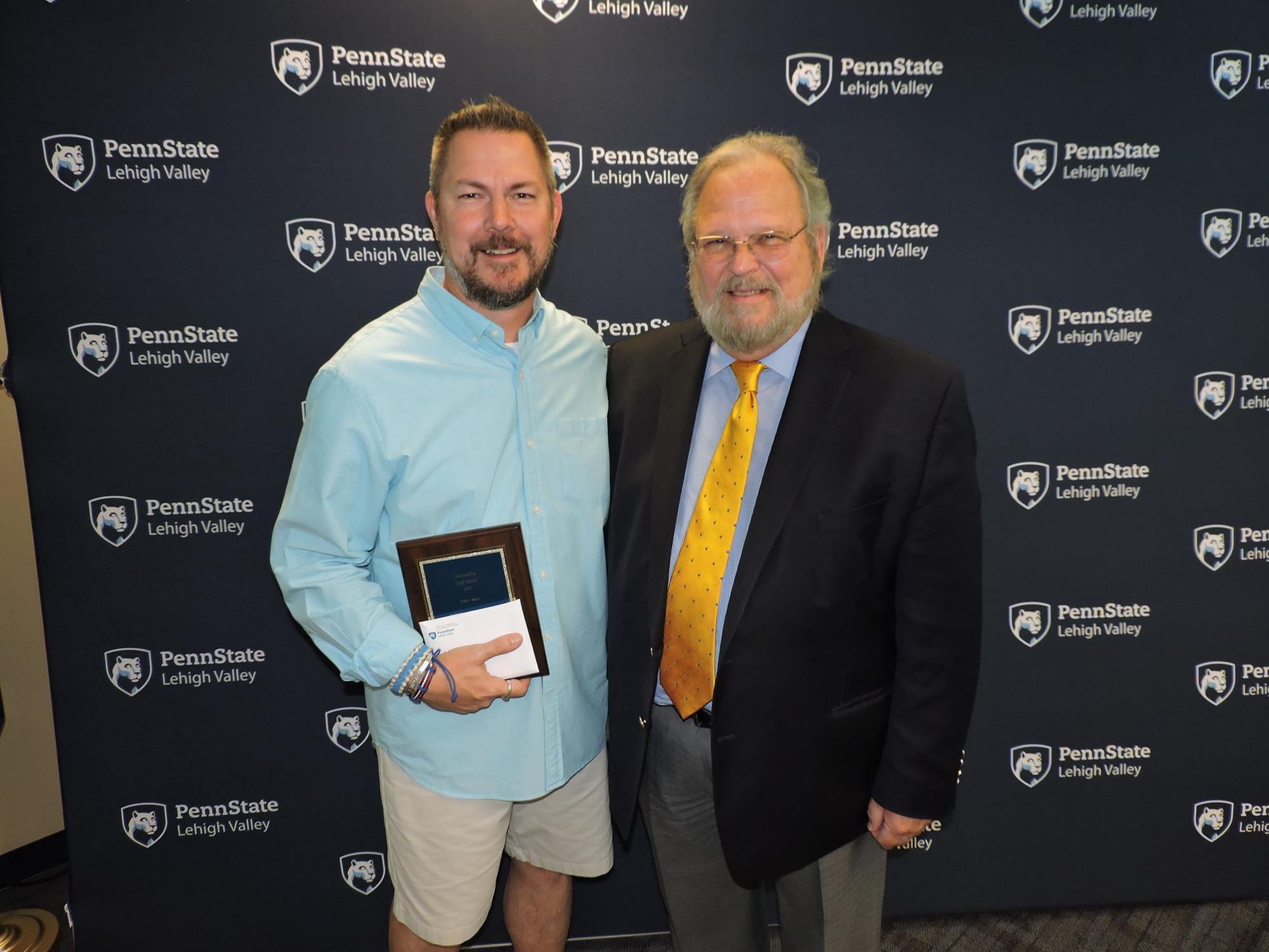 two men holding award