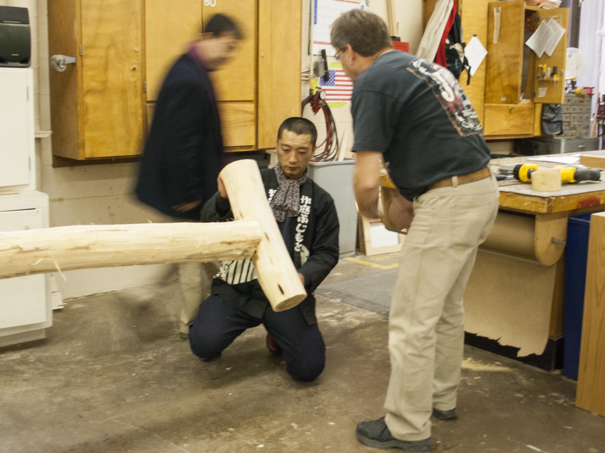Three men inspecting a traditional japanese tree crutch