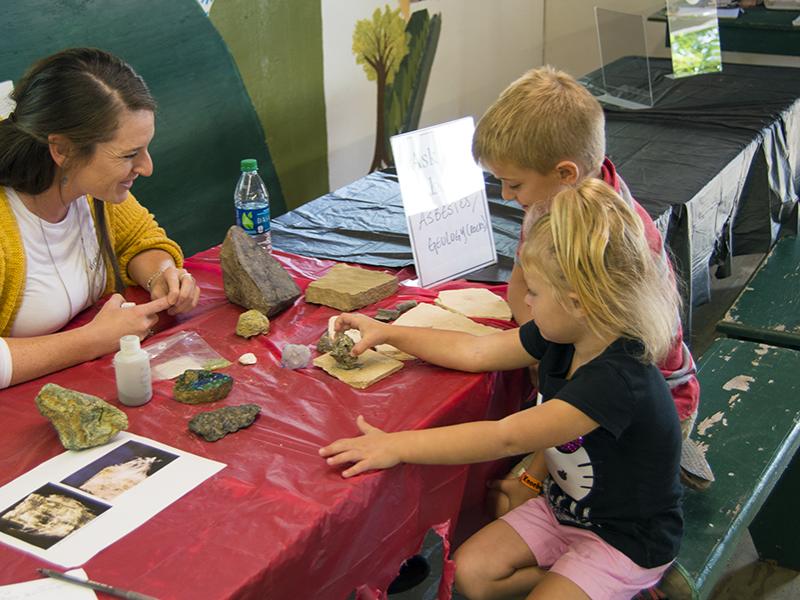 Virginia Marcon, a Ph.D. candidate in geosciences and co-president of the group WE ARE for Science, talks to children about the study of the Earth during the group's Ask a Scientist event recently at the Grange Fair.
