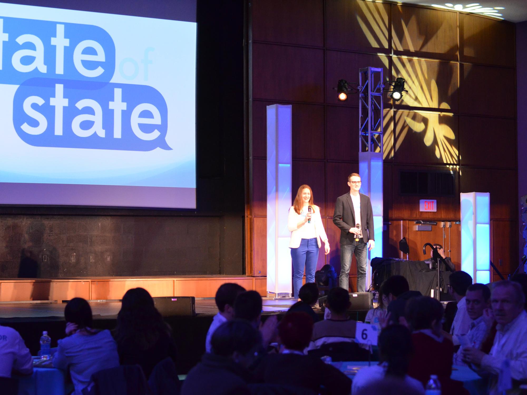 State of State creators and co-directors Suzanne Zakaria and Patrick Boynton speak on stage to kick off the conference