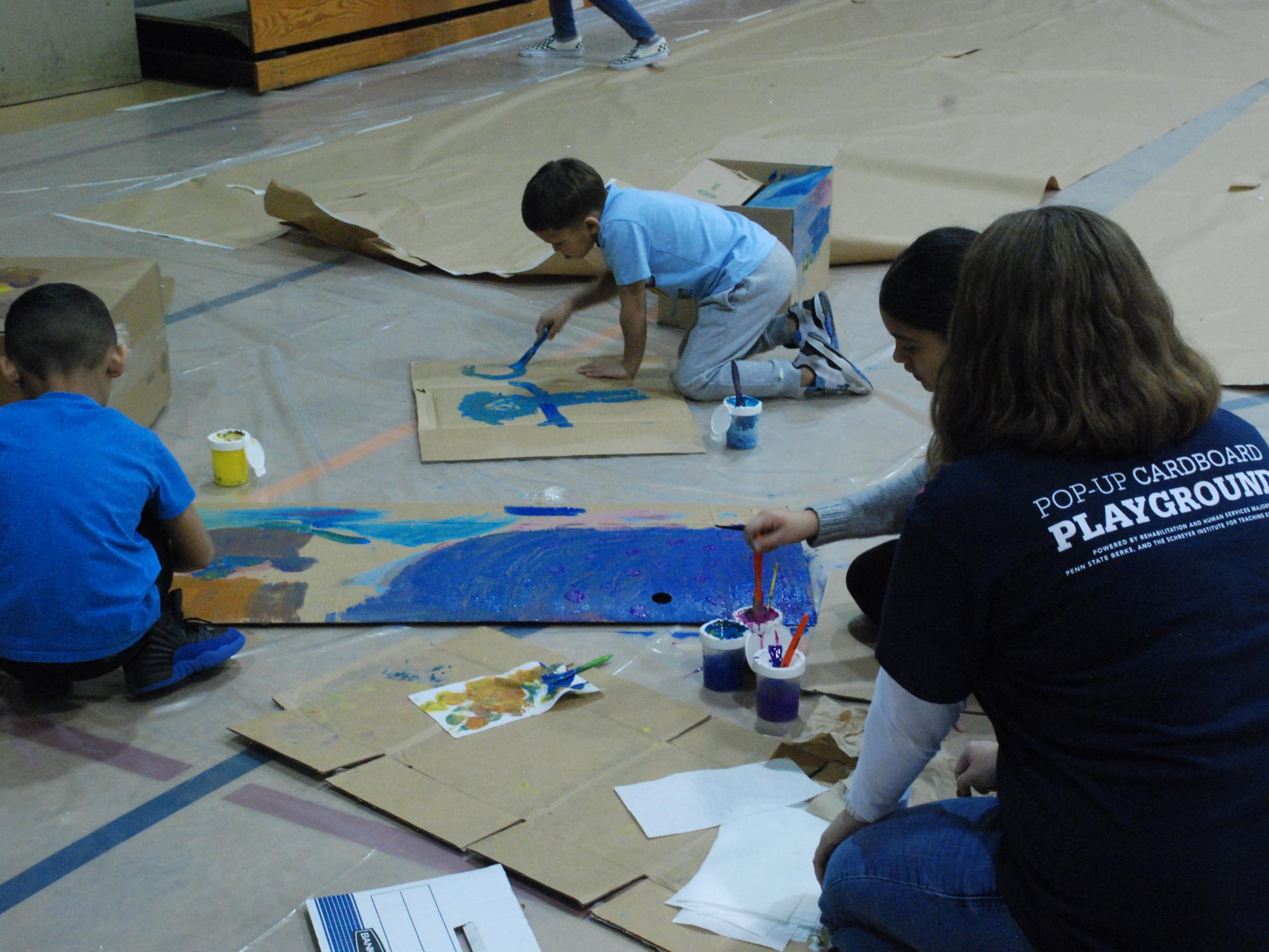 Children painting on cardboard