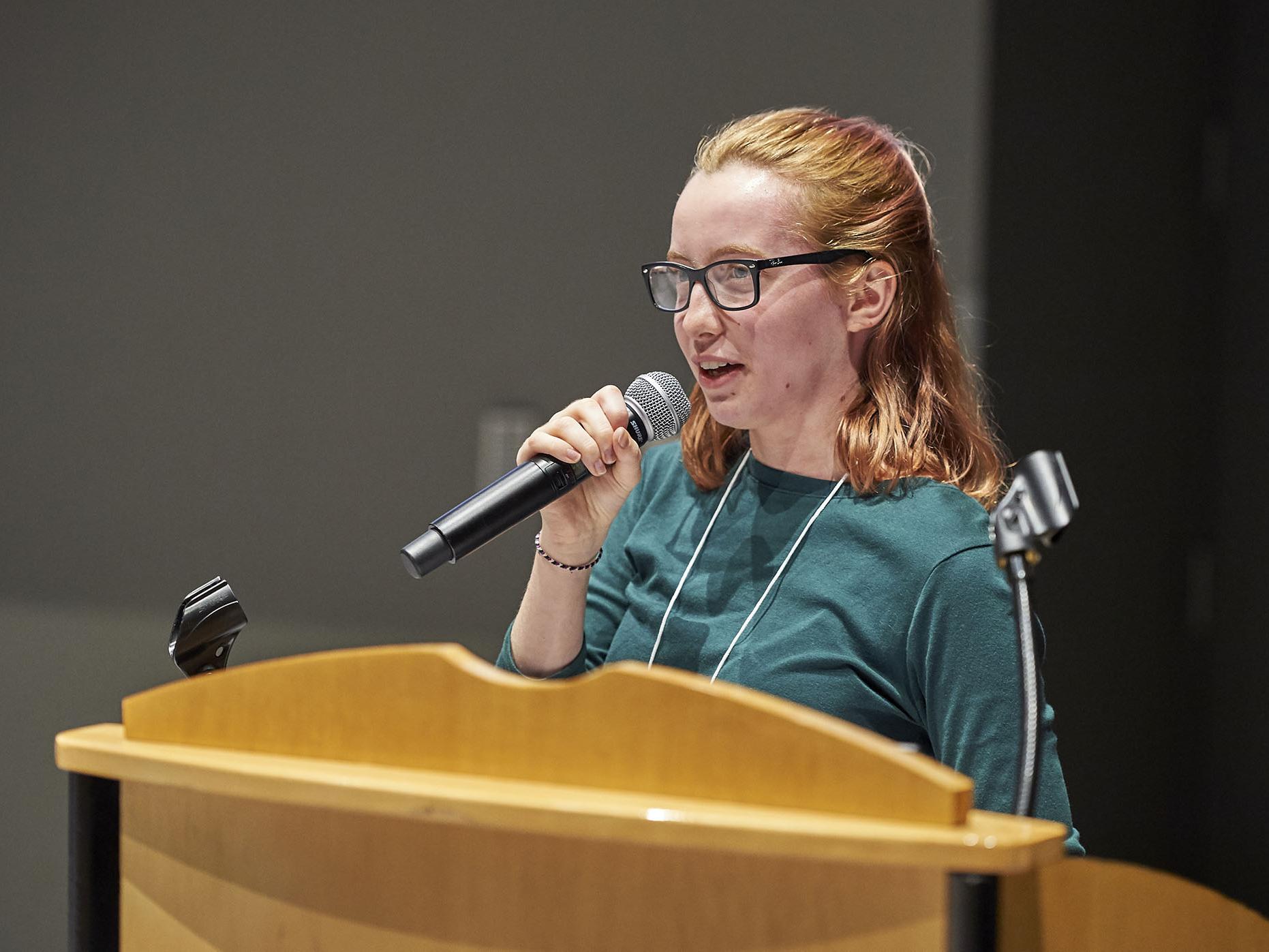 Hope Weidemann holds a microphone