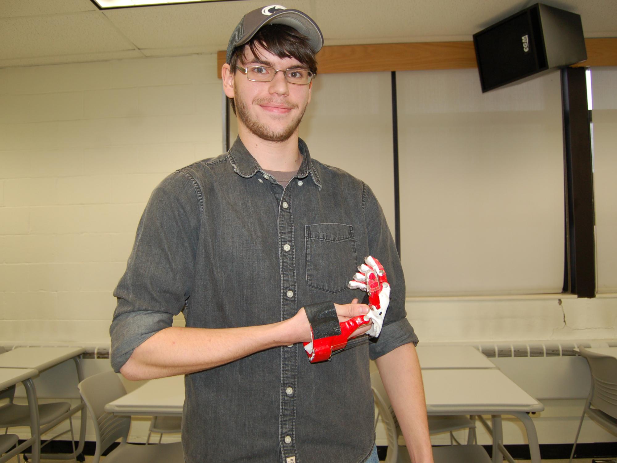 male student holding prosthetic hand