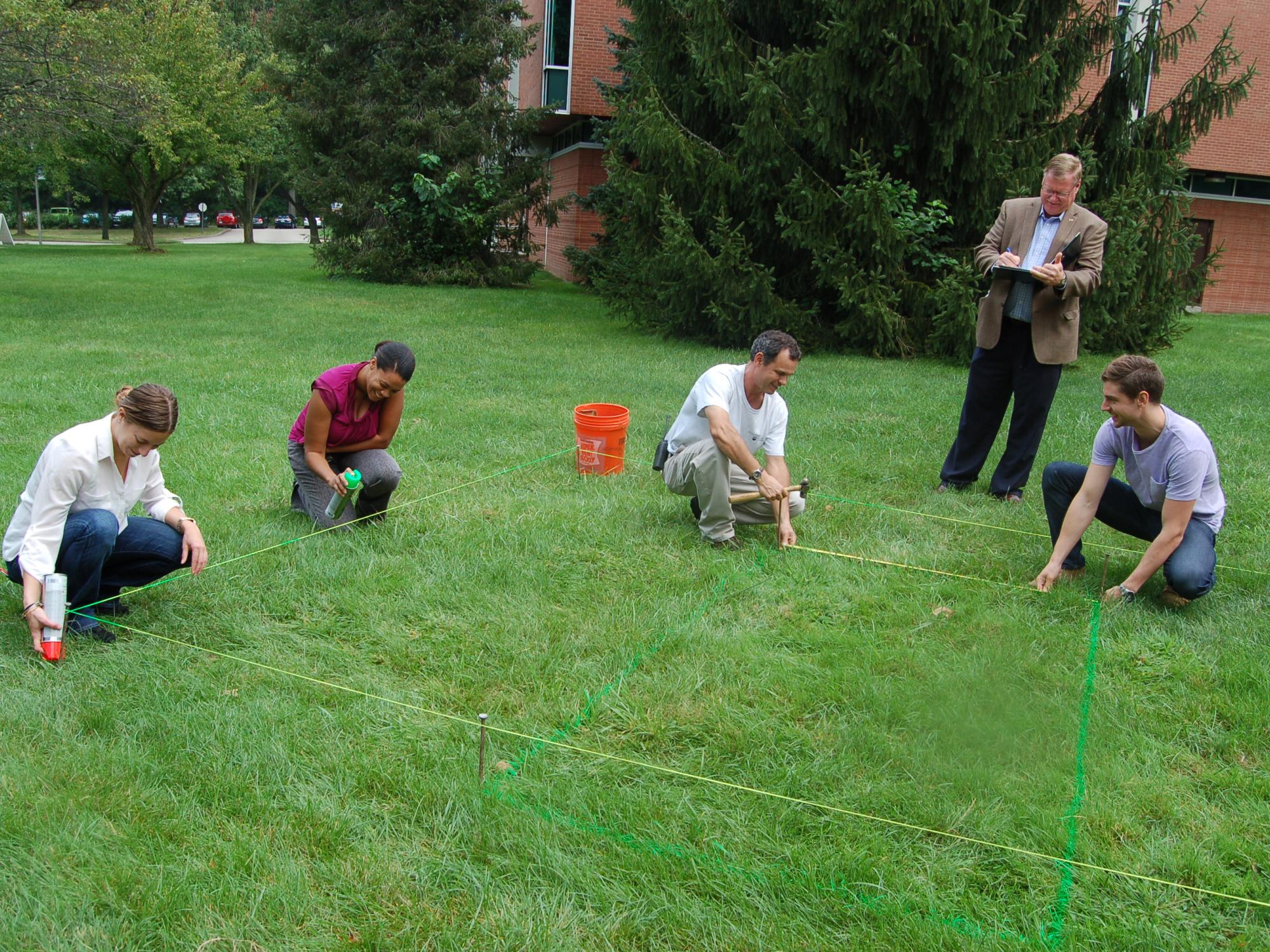 people measuring a garden