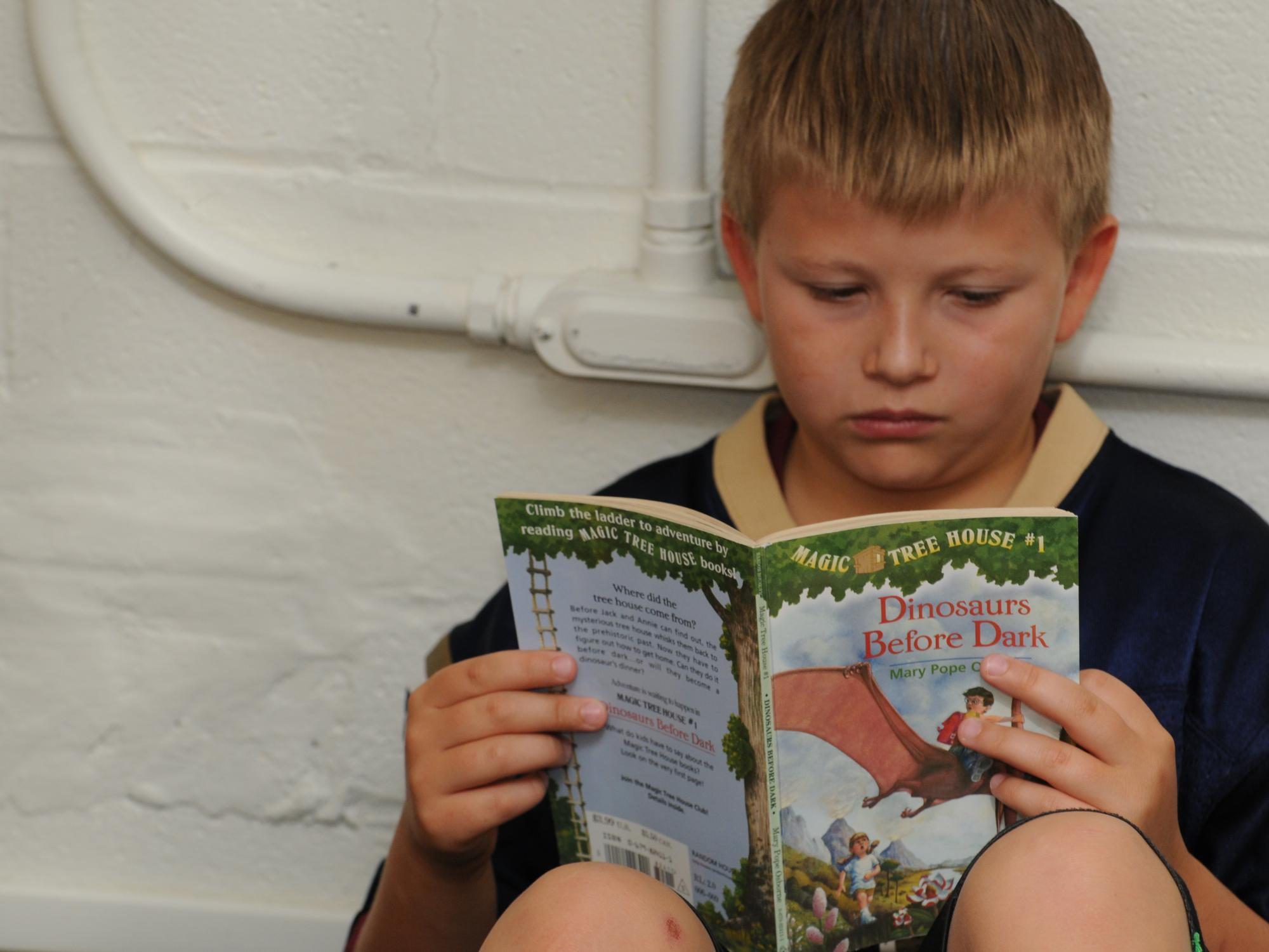 A student quietly reads a book at the College of Education's Summer Reading Camp. 