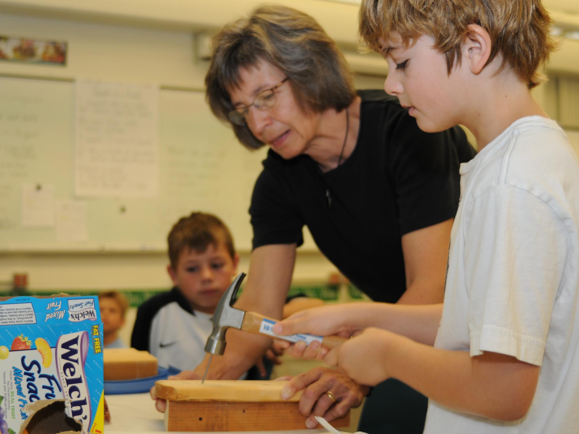 An instructor helps a student build a project during the Summer Reading Camp.