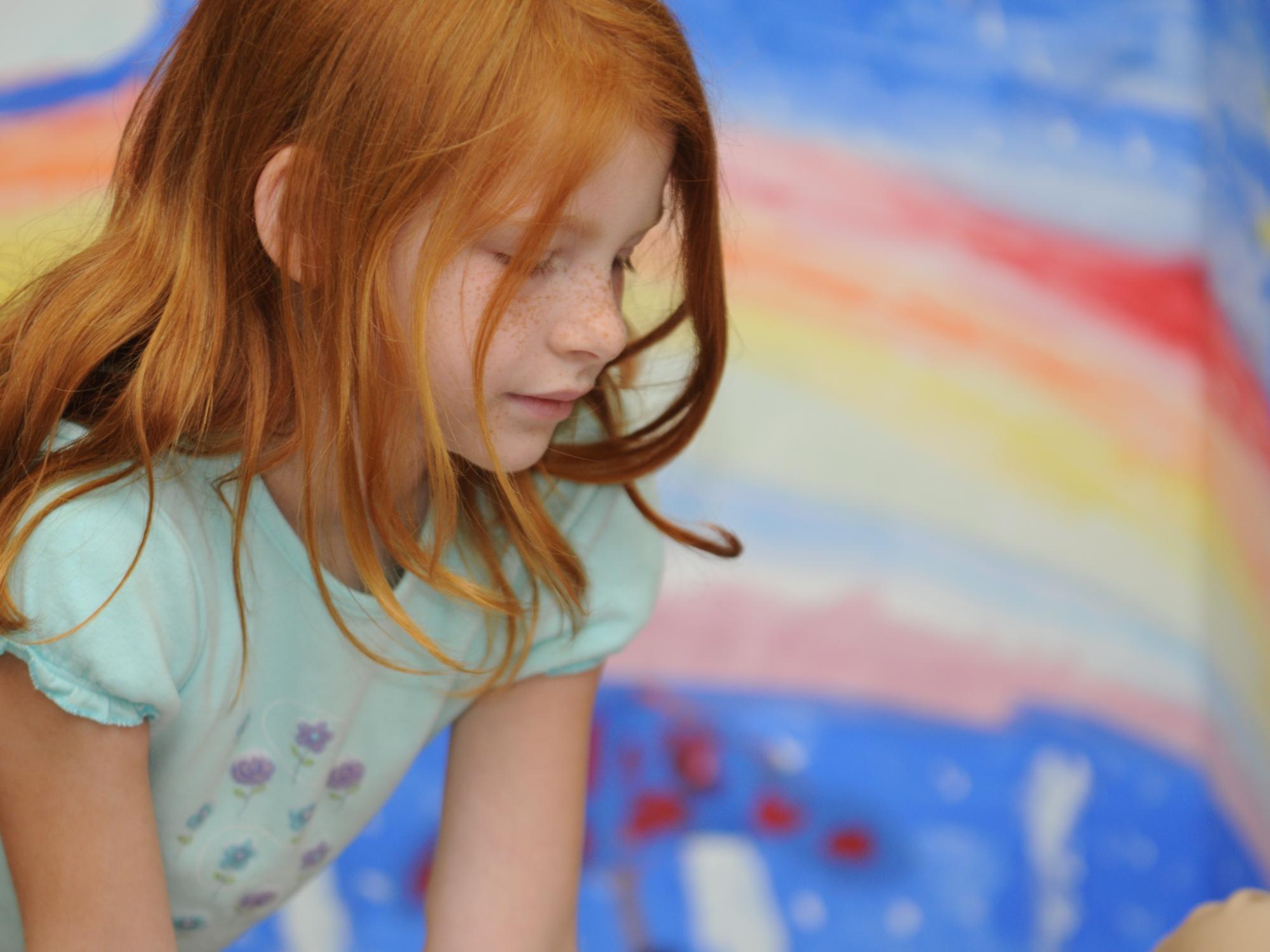 A student focuses on her art project at the College of Education's Summer Reading Camp.