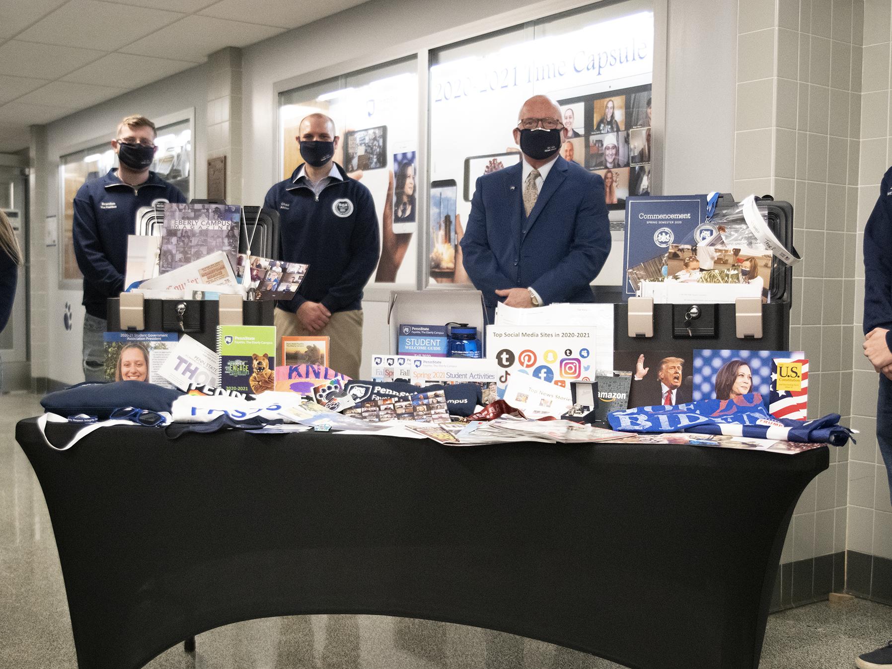 Campus and student leadership pose with items to be sealed in time capsule