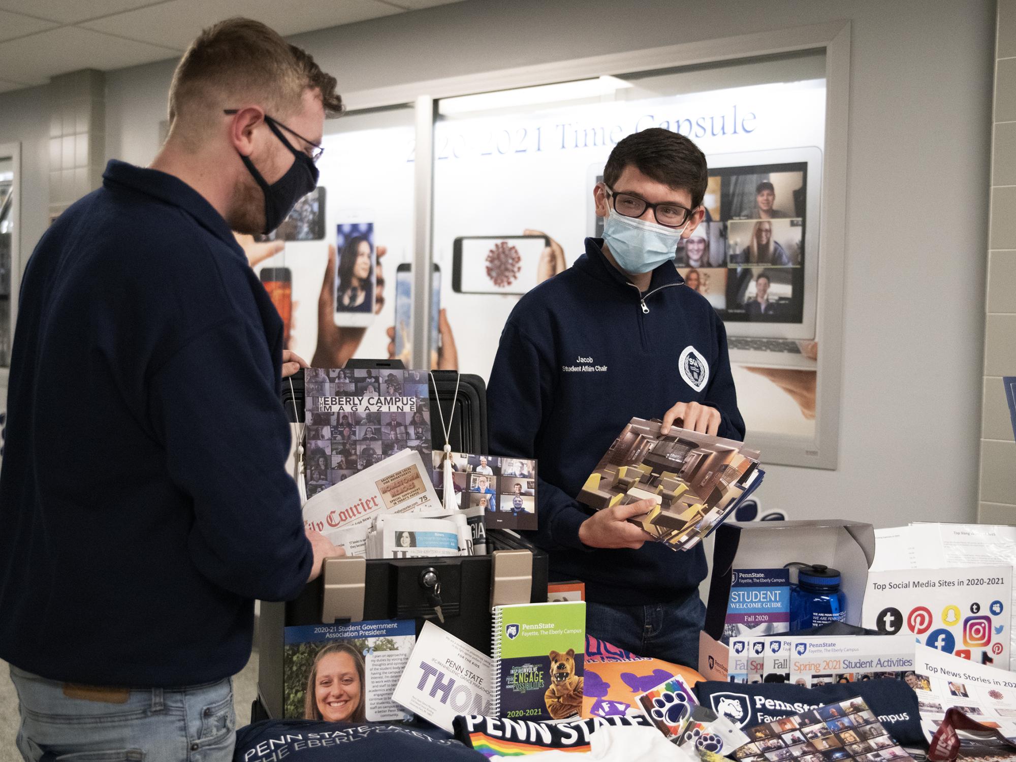 Brandon Demchak and Jacob Levendosky prepare time capsule items
