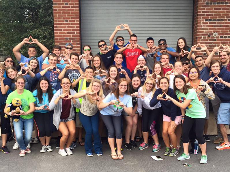 group of students posing and making diamond shapes with hands