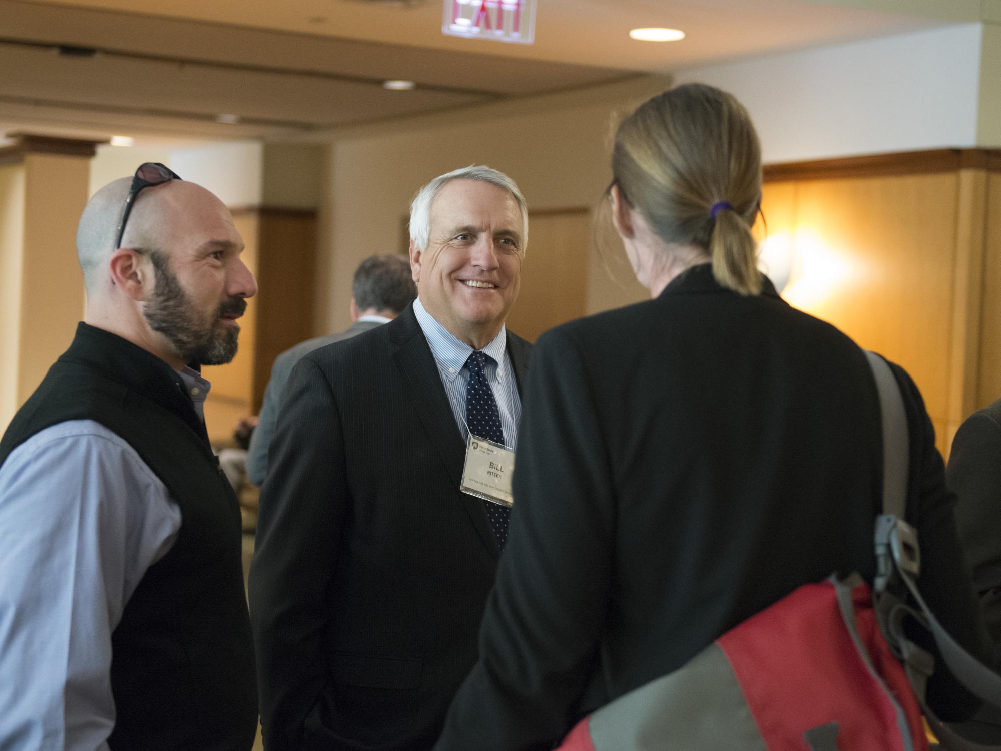 Bill Ritter, Jr. chatting with 2 others