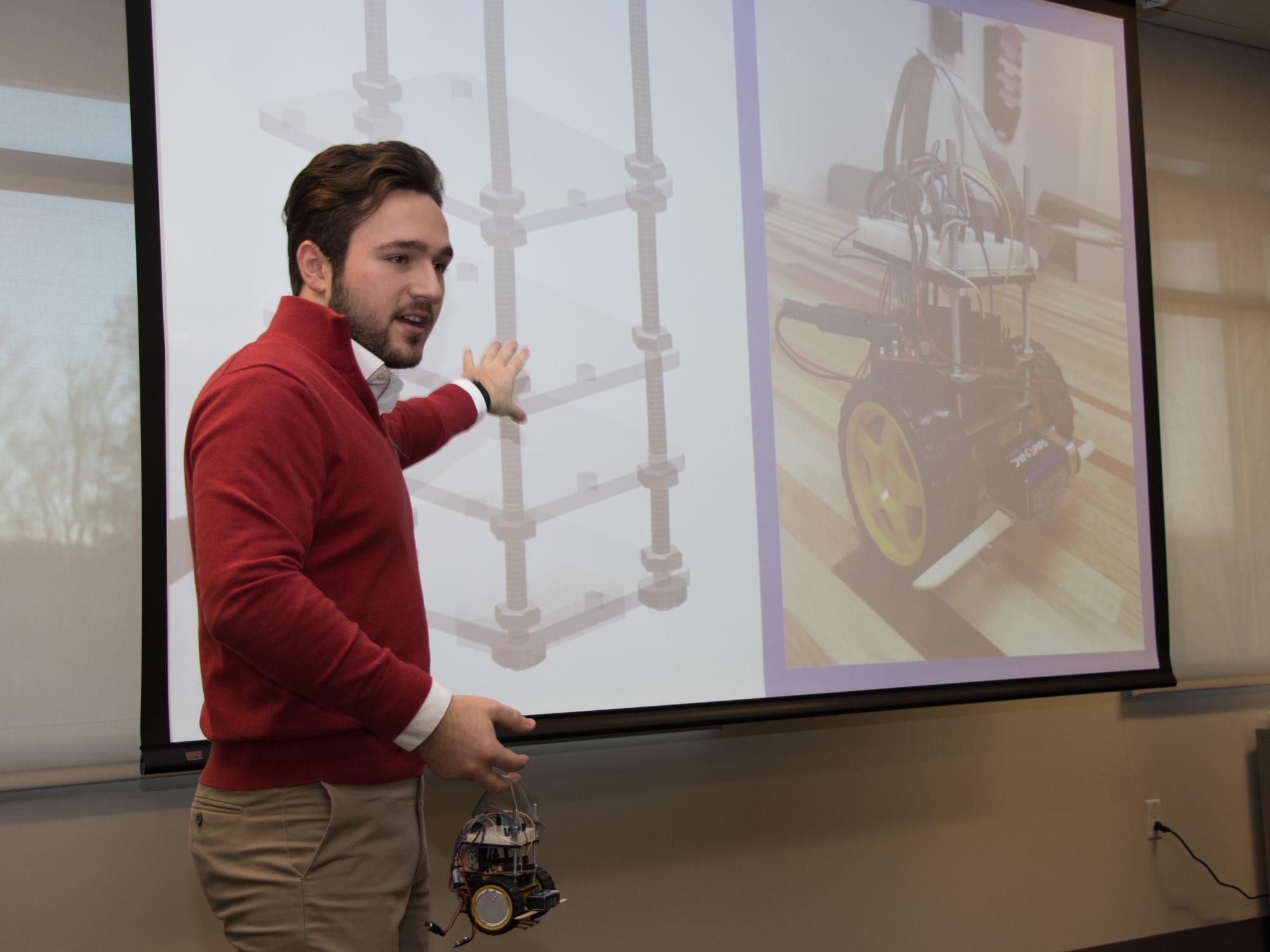 student points to slide to show how he made prototype