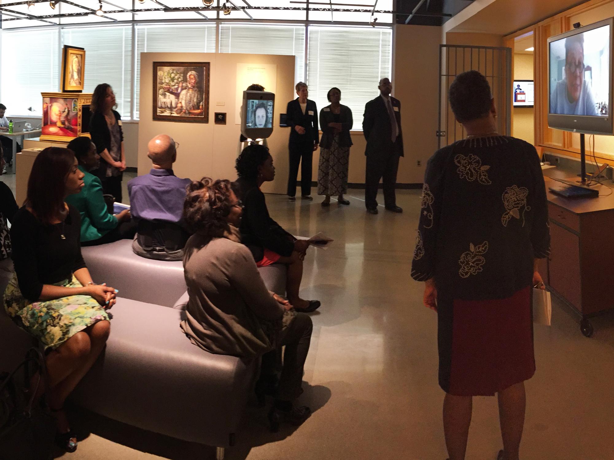 Artists talk to gallery visitors through Beam robot and Skype on a big TV.