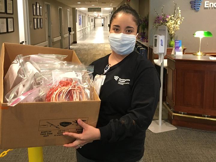 A member from Encompass Health holds the donated face shields.