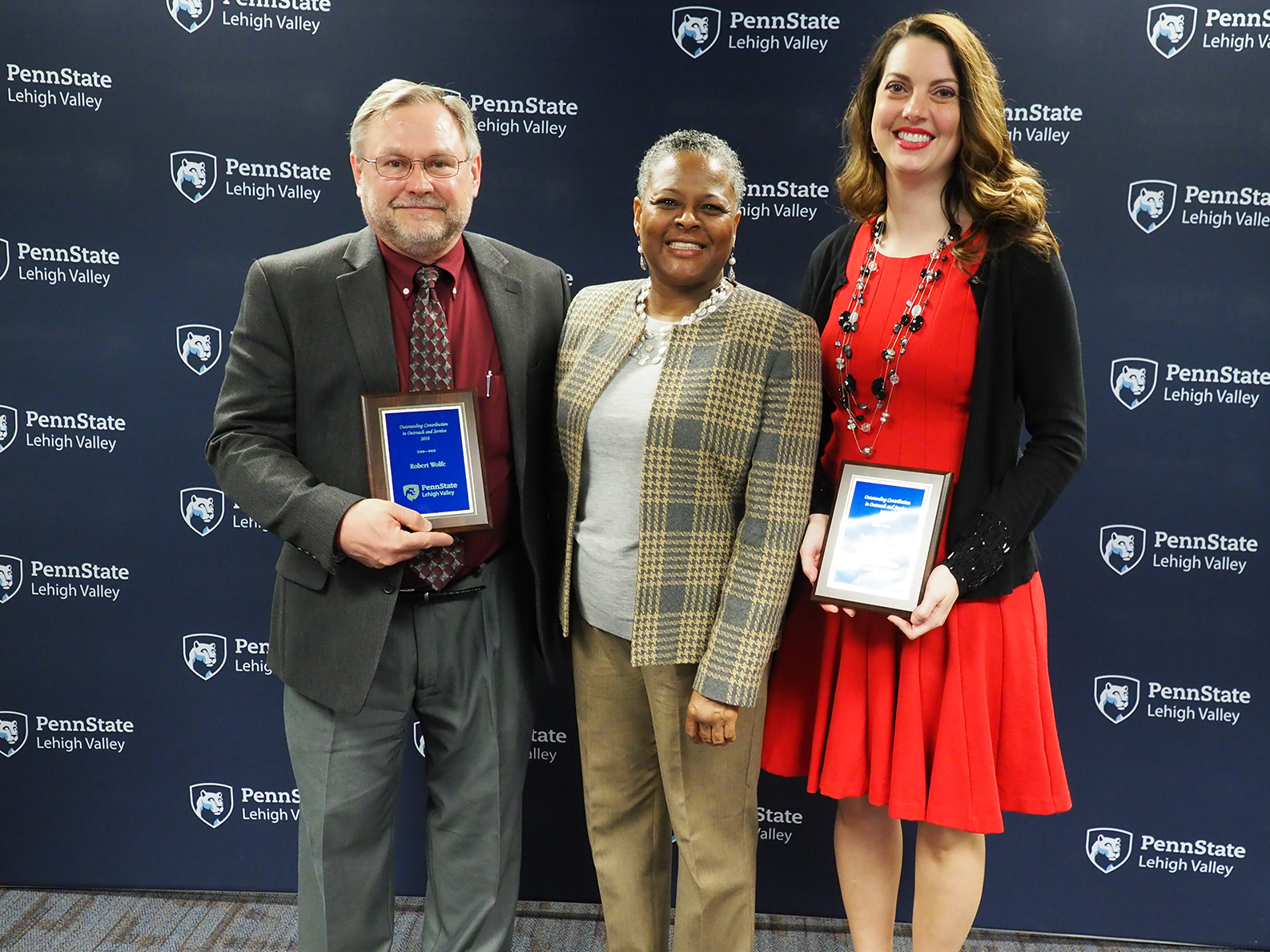 three people with plaques 