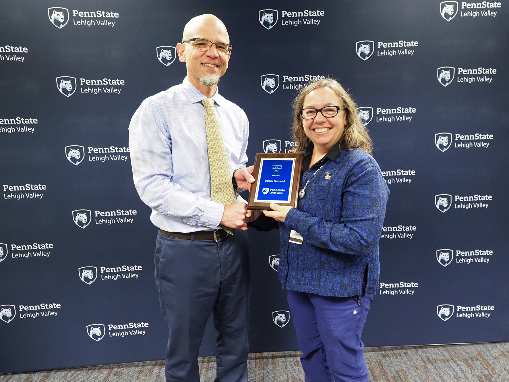 man giving plaque to woman