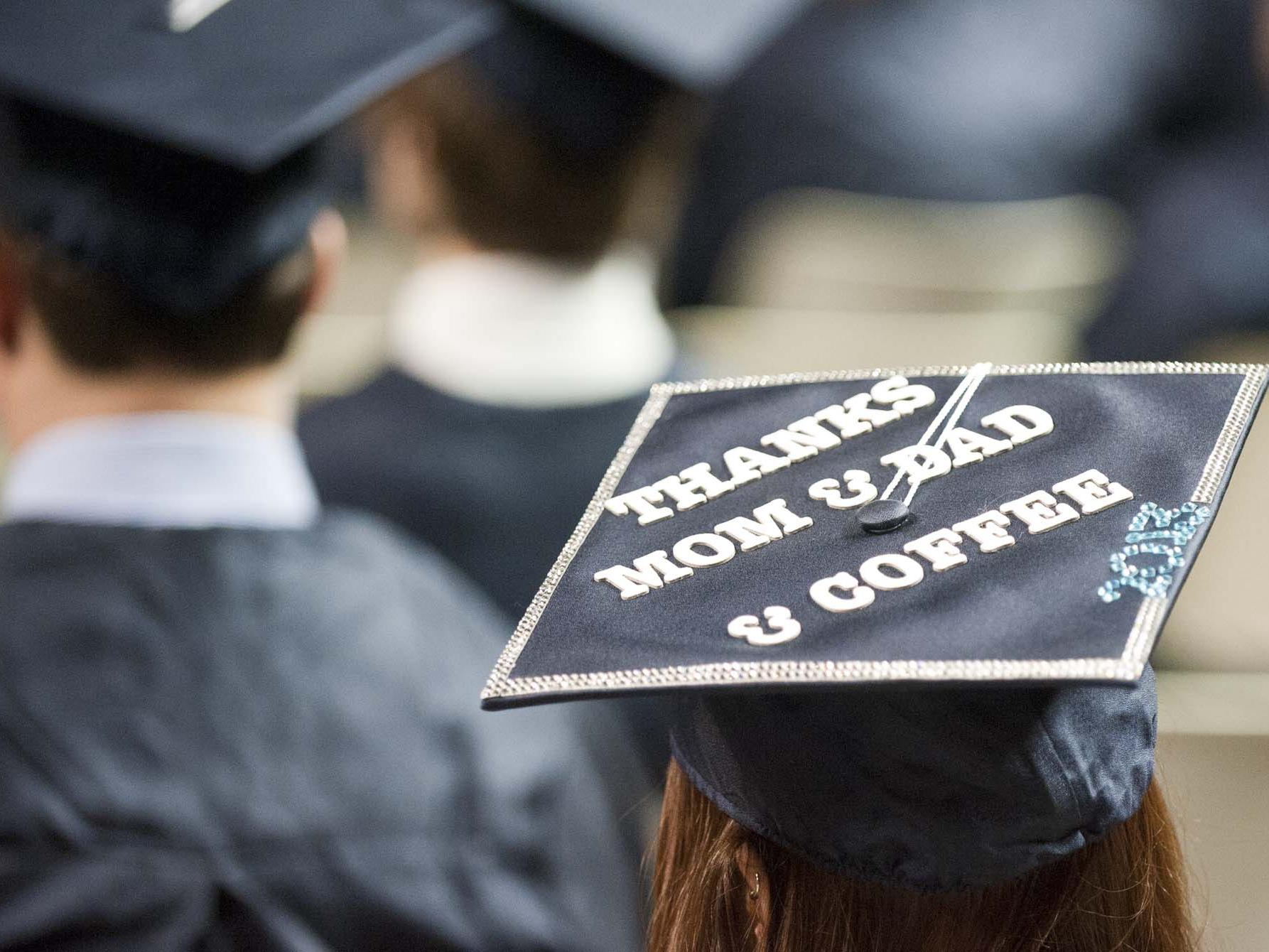 A student's decorate graduation cap reads "Thanks mom and dad and coffee"