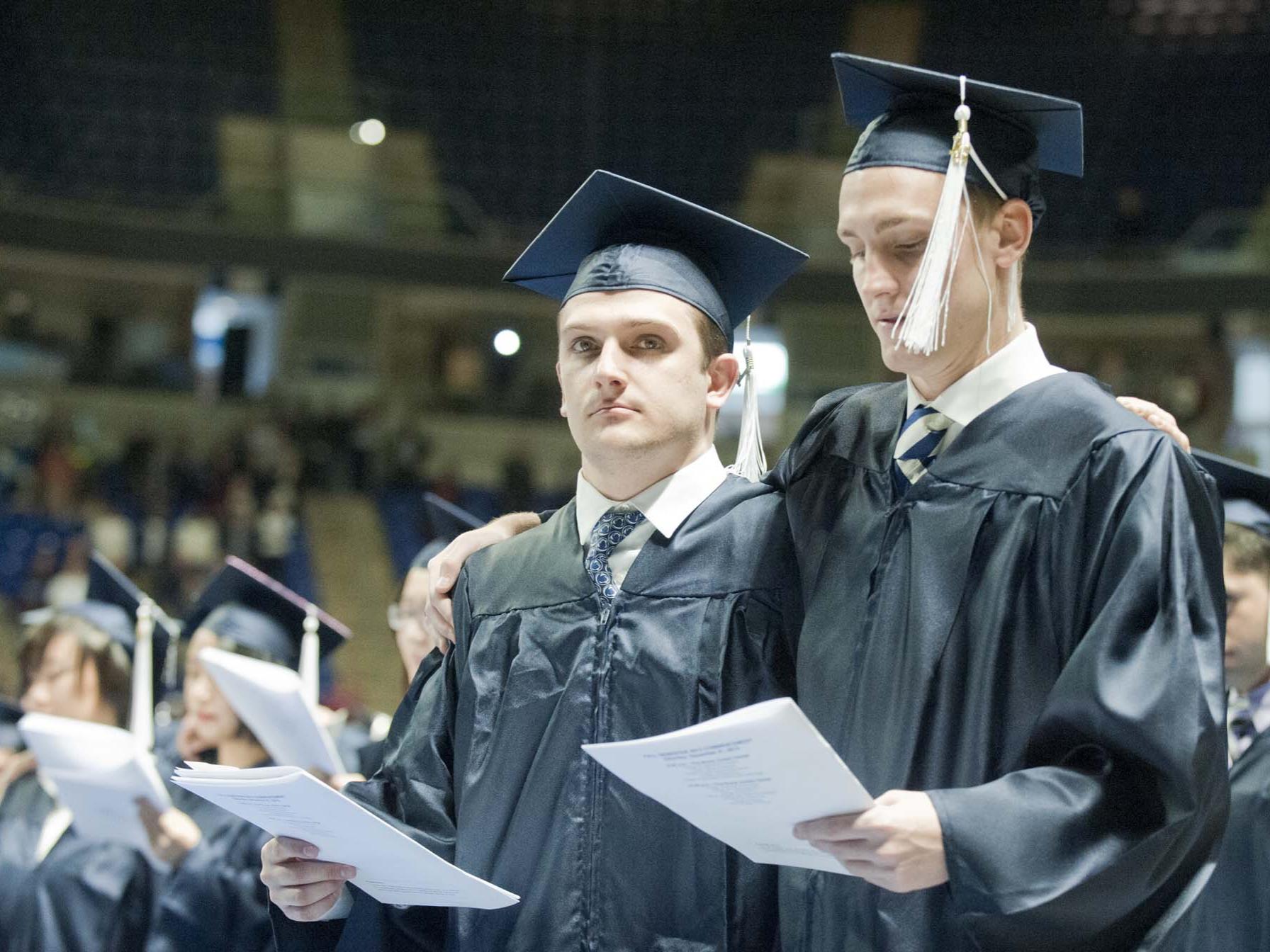 Two students singing the alma mater