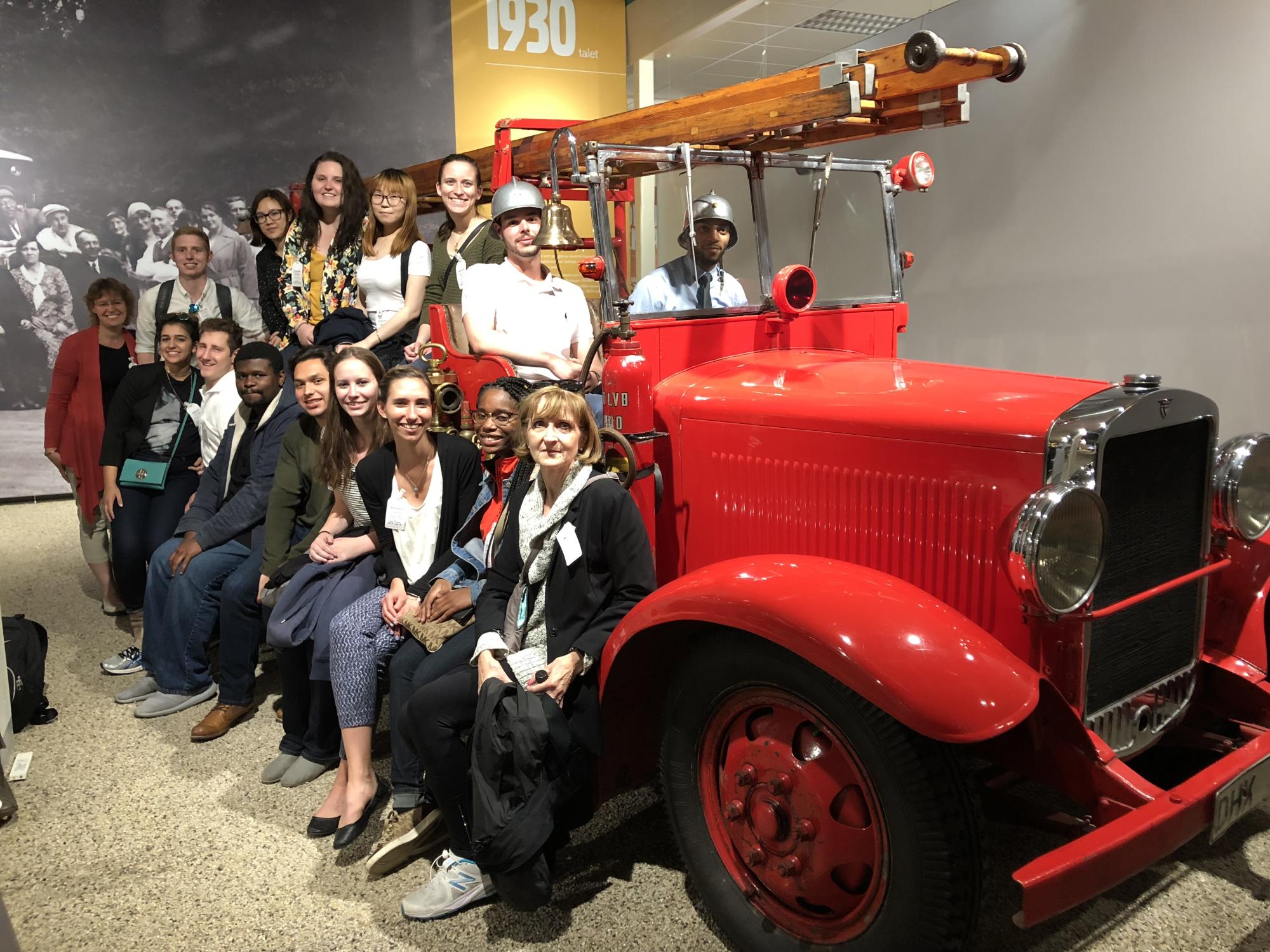 Students and faculty pose with firetruck in Volvo museum