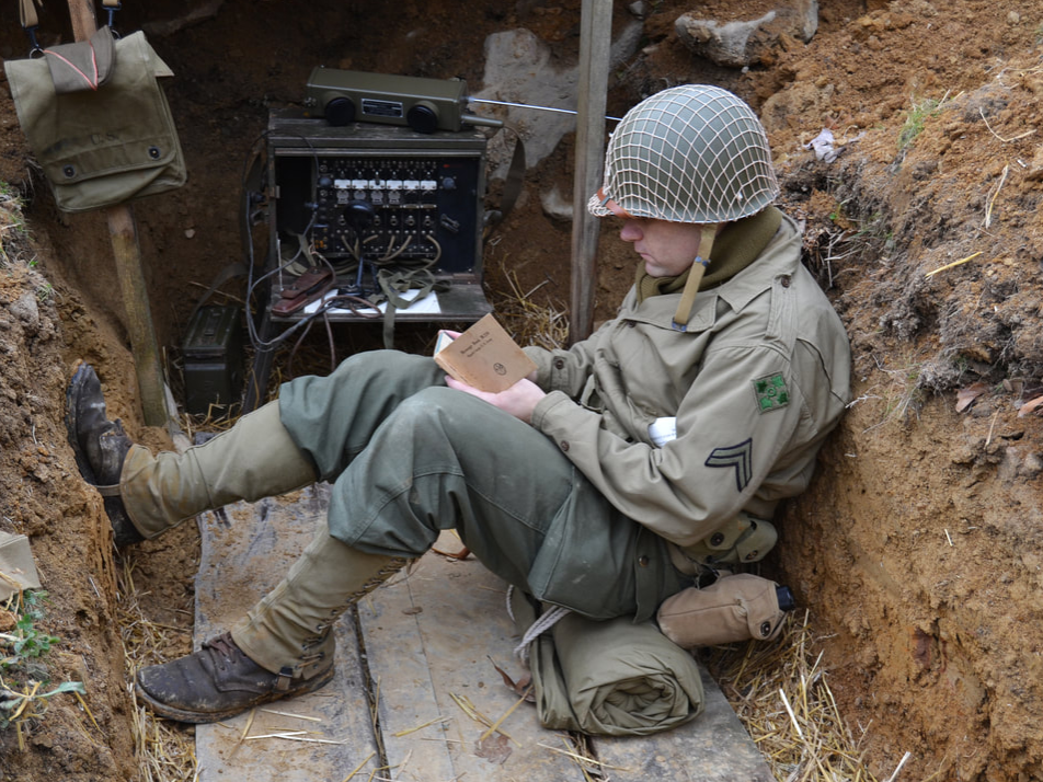 A WWII reenactor dressed as a soldier in a trench