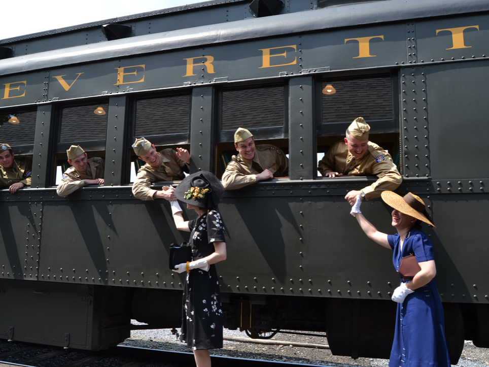 WWII reenactors pose near a train
