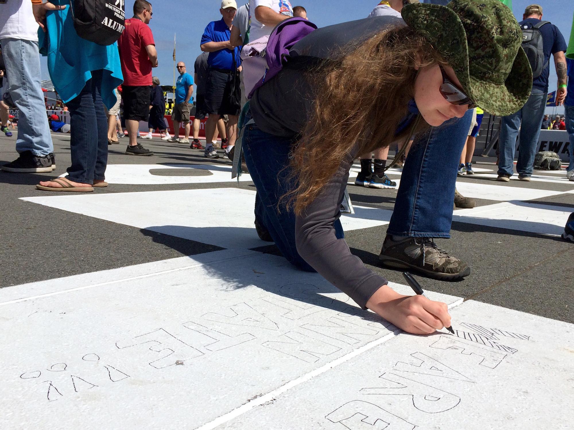 Student writing "We Are Penn State"