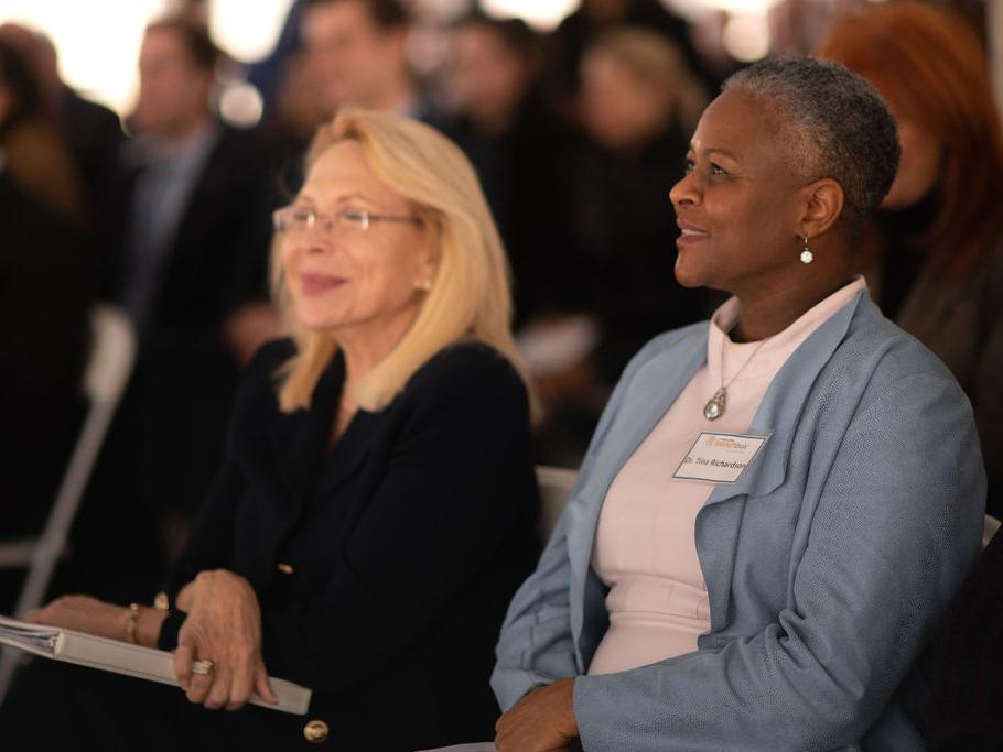 two women listening to speaker