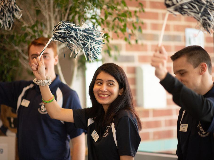 three students with pom poms
