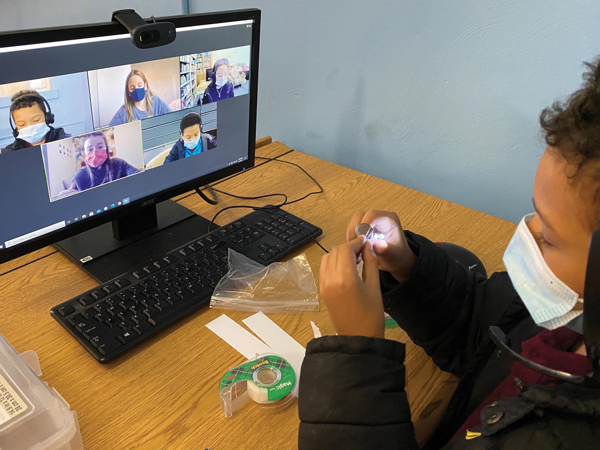 An elementary student works on a science experiment with his pre-service teacher from Penn State via Zoom.