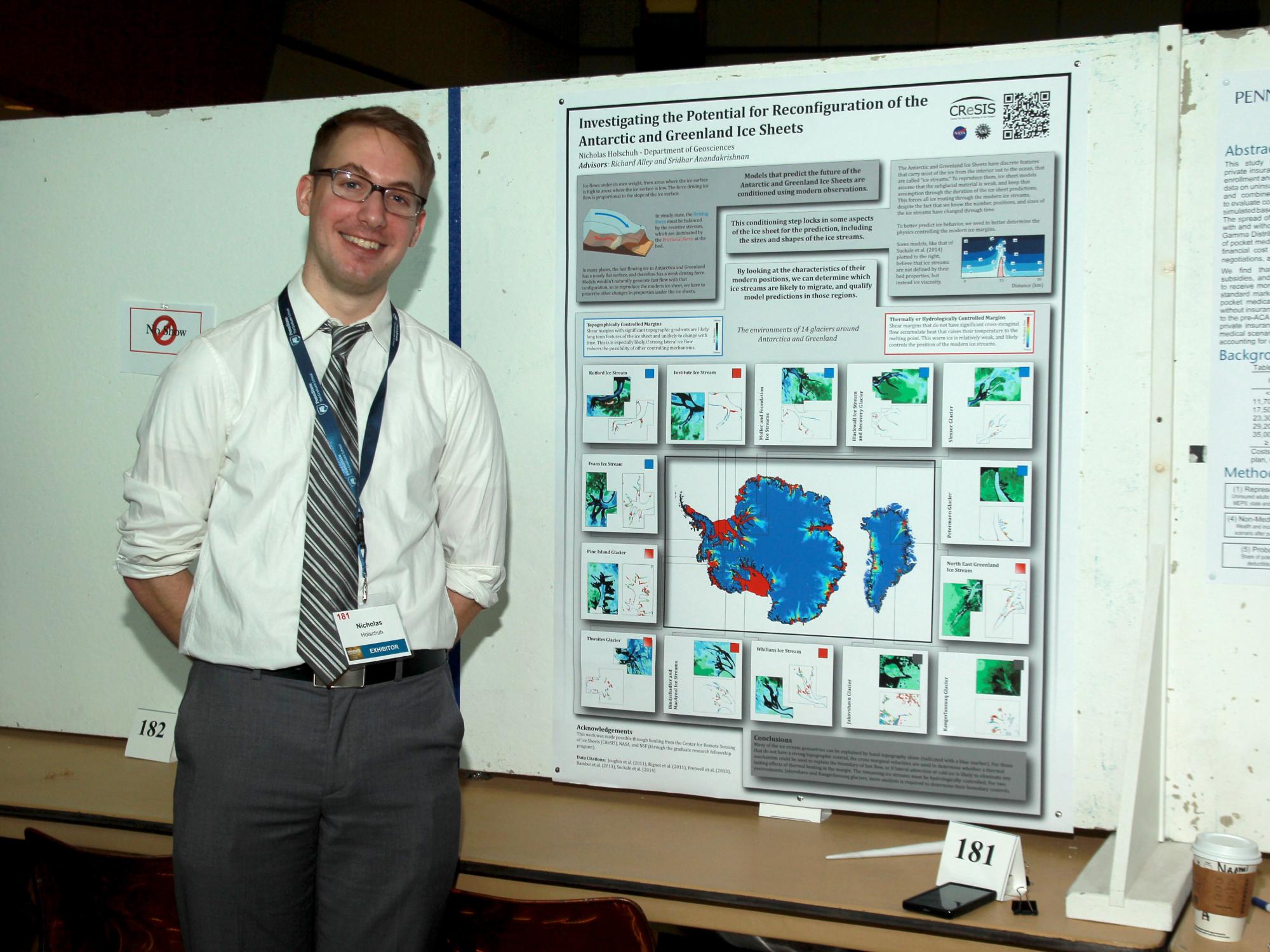 student standing next to research poster