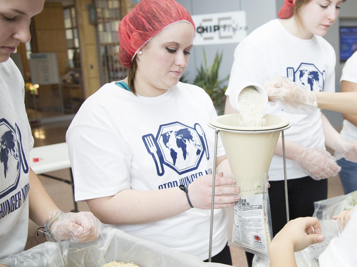 A student holds a food pouch as it is filled.