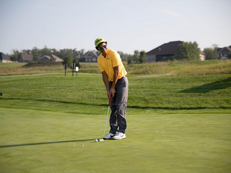 Golfer putts at golf outing