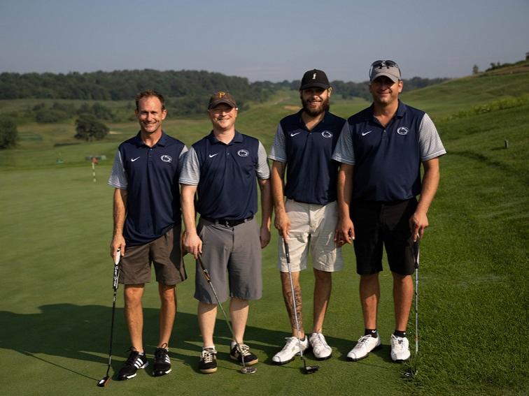 Four golfers standing on putting green