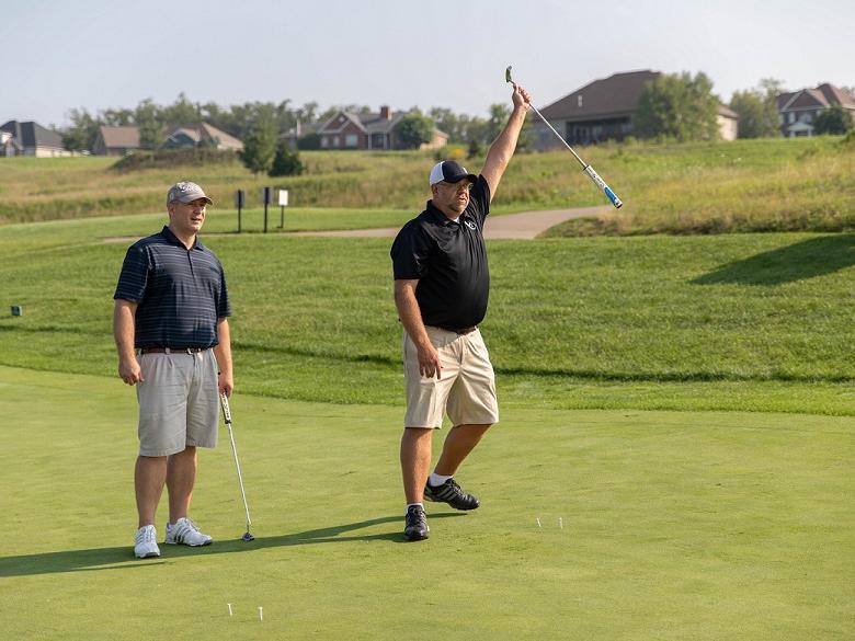 Two golfers on putting green