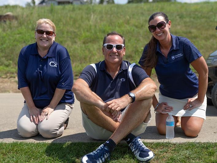Three alumni society members at golf outing