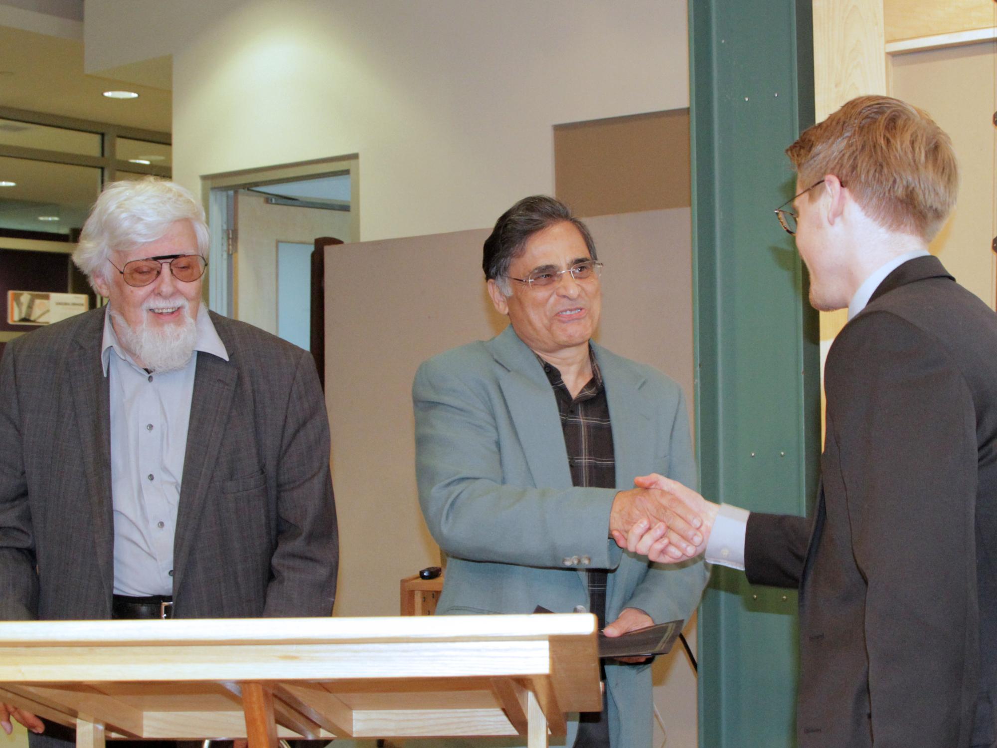 Dustin Julius shaking hands with Jawaid Haider 