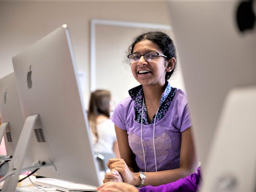 Female student sits by computers
