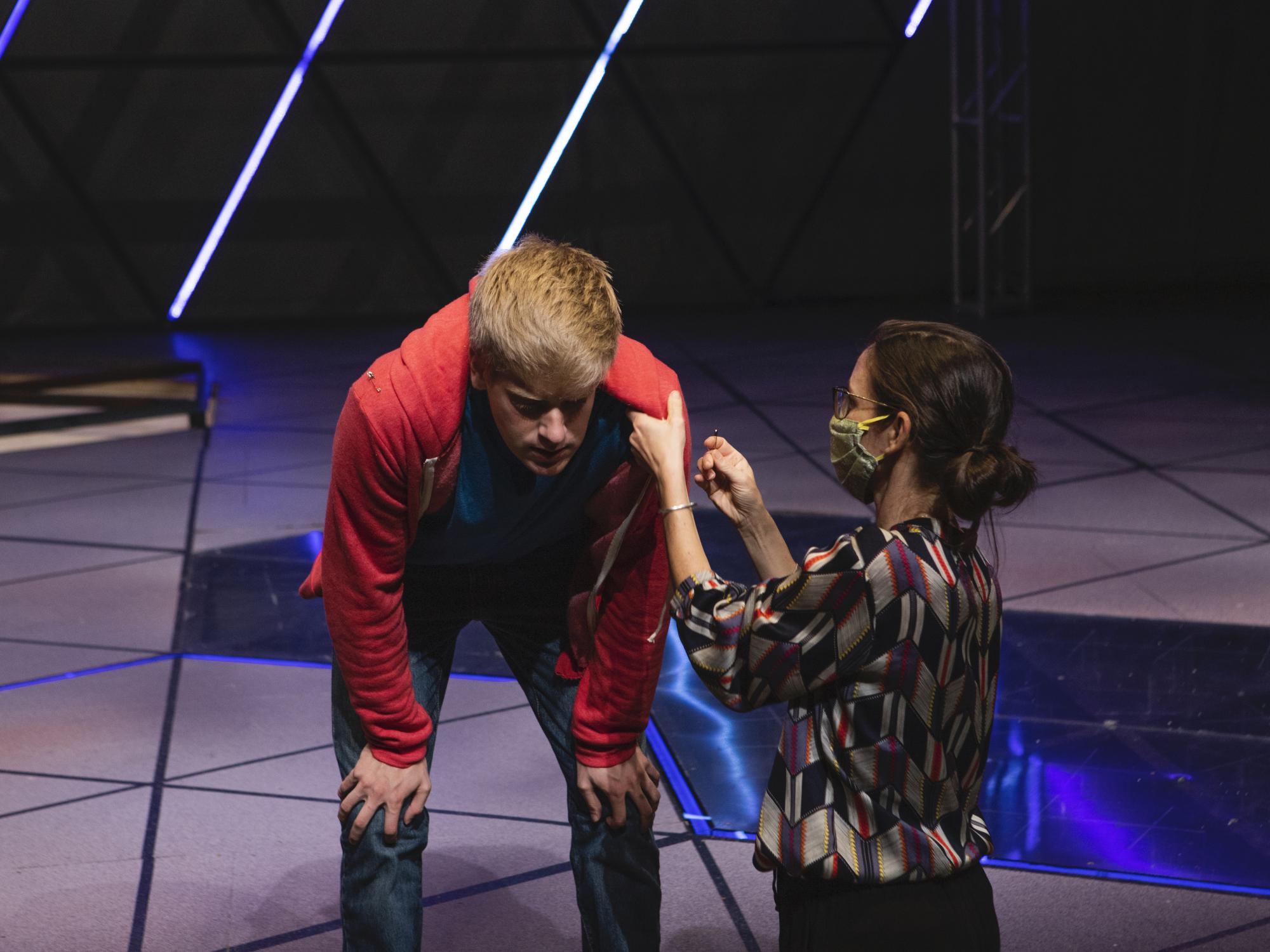 a person helps with an actor's costume