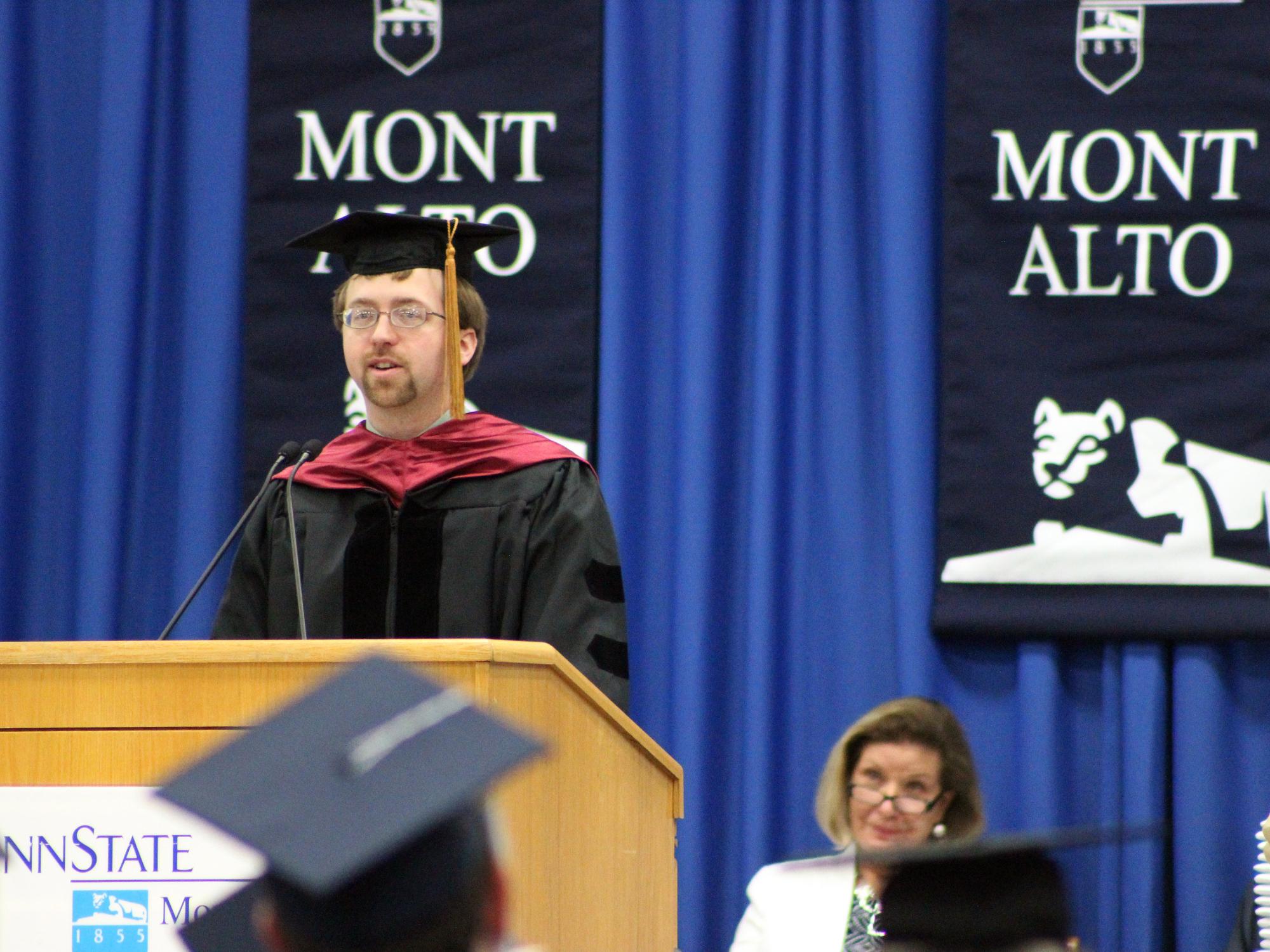 Jacob Moore speaks at a podium at Penn State Mont Alto's commencement.