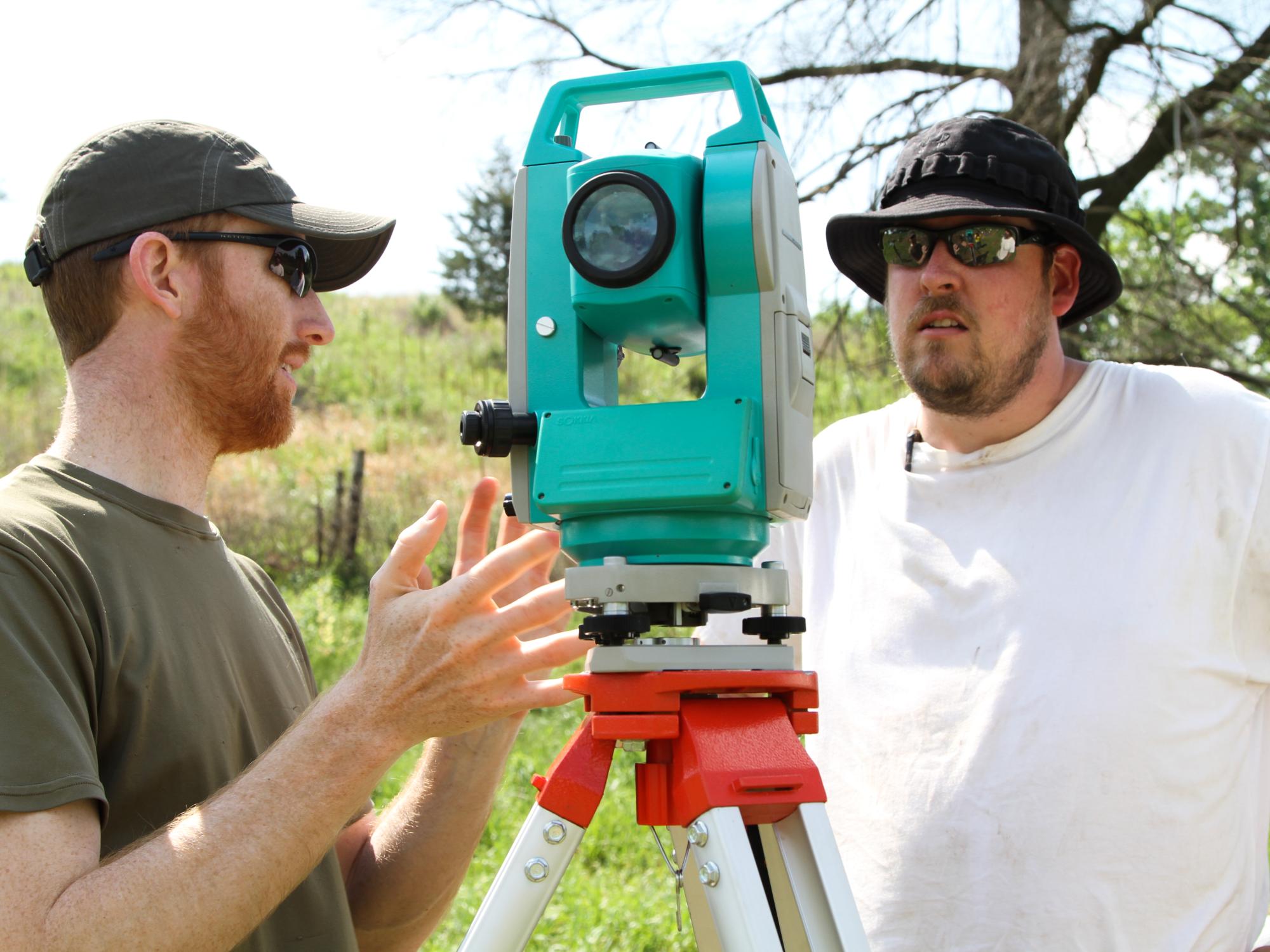 Chris Frey explains the total station to a field school participant.