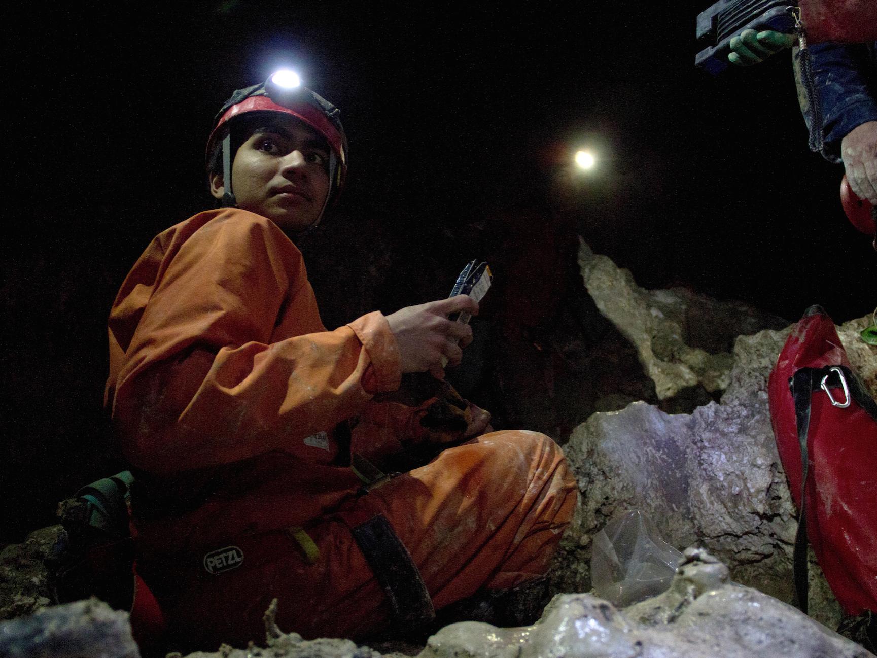 A Penn State astrobiology student's headlamp lights a dark cave in Italy during a recent field course 