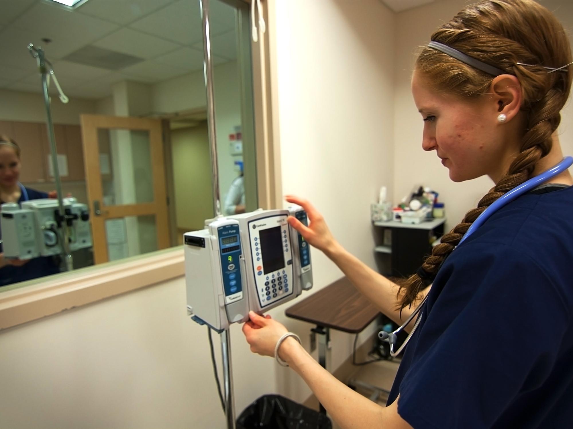 Natalie Sullivan checks the monitor on a patient's IV stand. 
