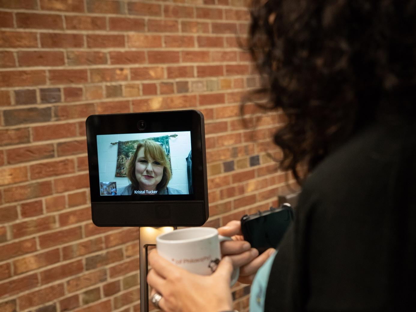 Kristal Tucker speaks with another faculty member with robot