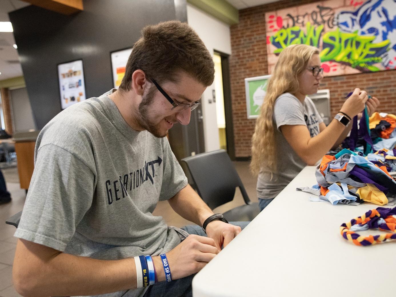 Students making dog toys from recycled shirts
