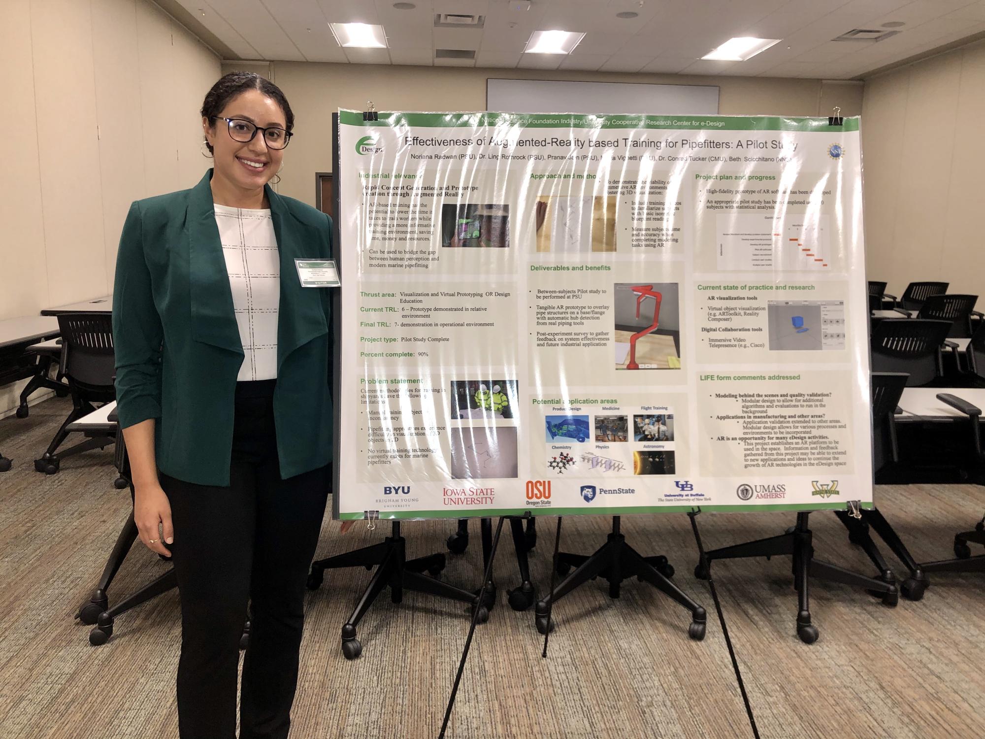 Woman in business attire stands with academic poster.