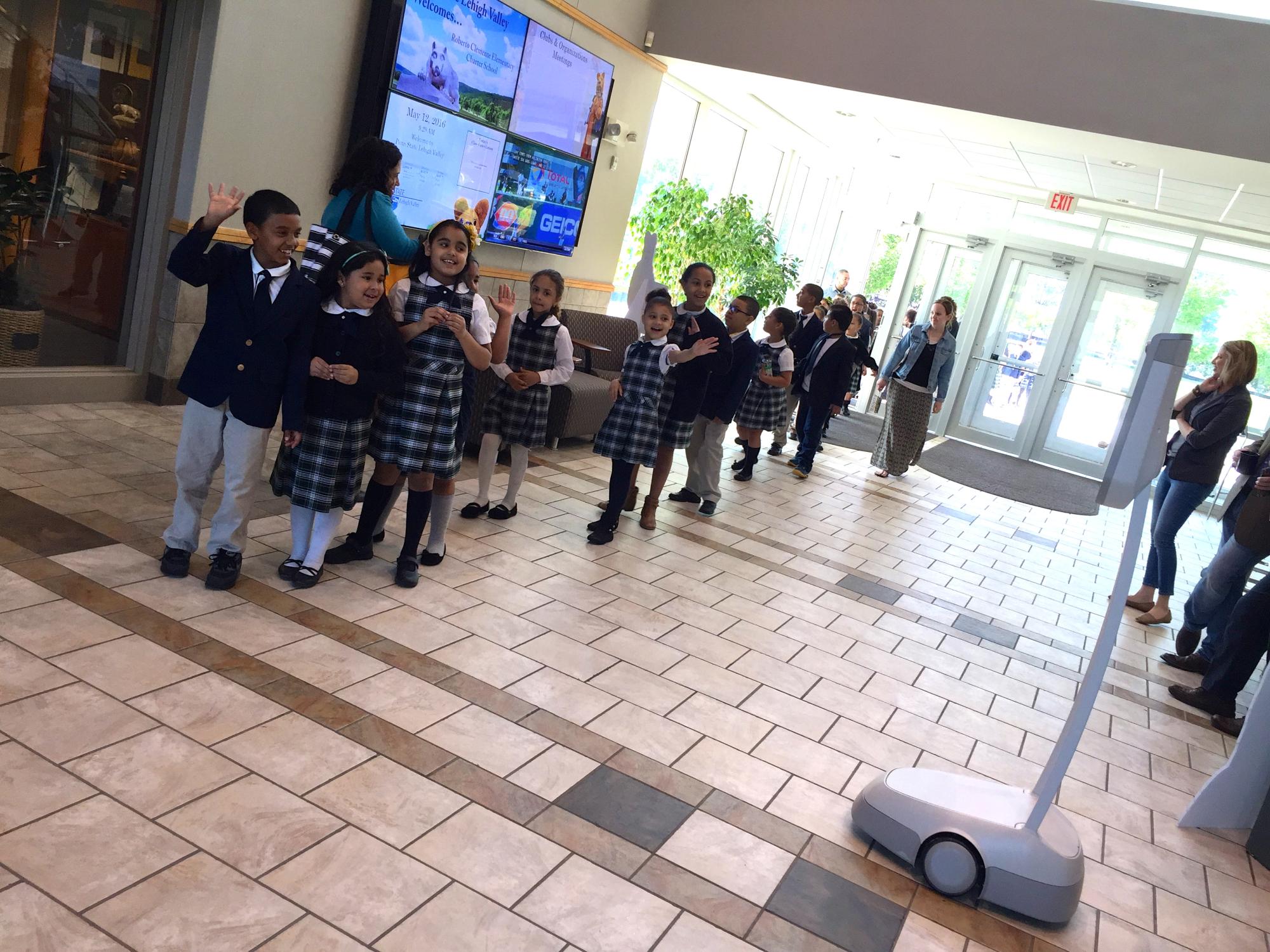 Students file in doors as principal greets them on Beam