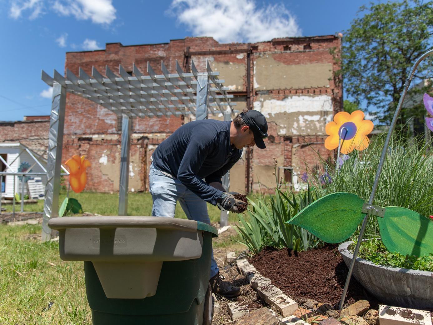 Man puts mulch in garden bed
