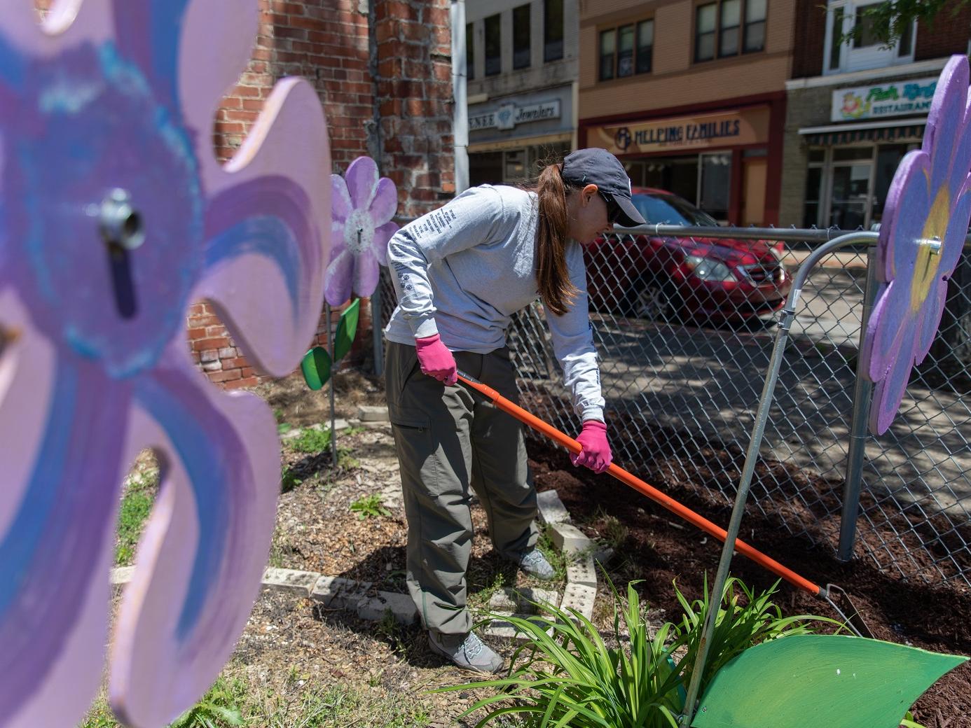 Woman spreads mulch in garden