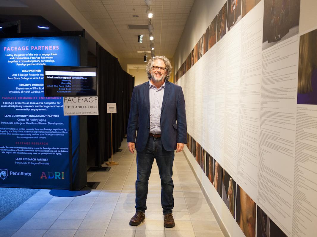 Andy Belser stands in the FaceAge exhibition.